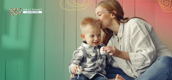 A mother kisses a young child's forehead